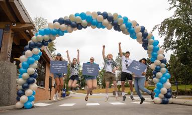 students welcoming under a balloon arch