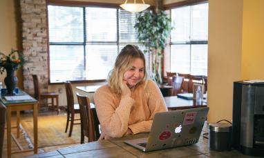 female student looking at laptop and smiling