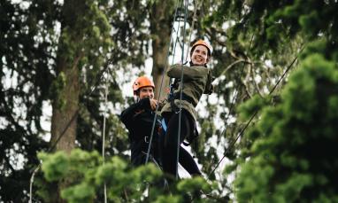 two people on high ropes in trees