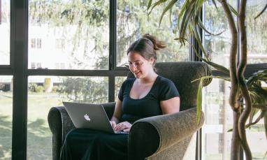student using a laptop and smiling
