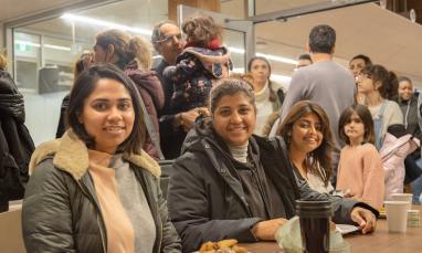 women sitting at a table smiling at the camera