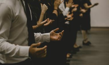 line of people worshiping with their hands lifted at their sides