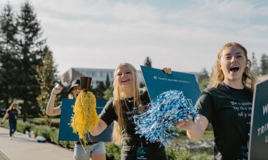 students cheering at orientation for new students near university entrance