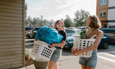 students holding baskets of belongings to move in to dorms