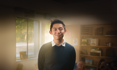 Sean Hui standing in front of classroom with light behind