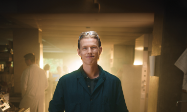 Spencer Funk standing in lab with light behind him