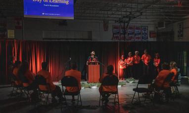 Day of Learning speaker talking in gym