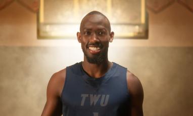 David standing with light behind him in a basketball court