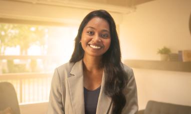 Rebecca standing in a room smiling at the camera