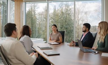 A group of people around a table with laptops