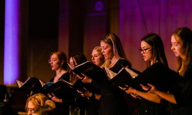Singers from a concert standing in a line holding their sheet music
