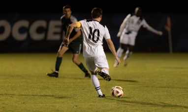 A picture of a man kicking a soccer ball.