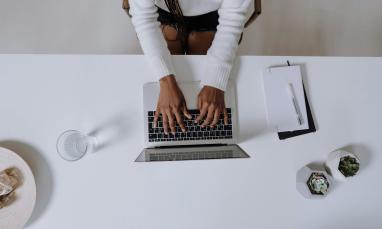 Person typing on a laptop keyboard.