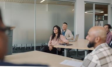 People smiling in a modern conference room.