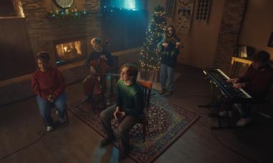 people playing music in front of Christmas decorations