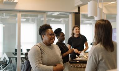 People smiling and talking in an office building