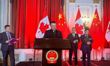 Man at podium addressing audience for award ceremony.