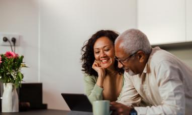 Couple smiling looking at a laptop together