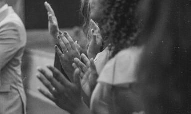 Black and white photograph of a group of people praying in worship