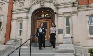 two women walking down the steps of the Laurentian Leadership Centre in business attire