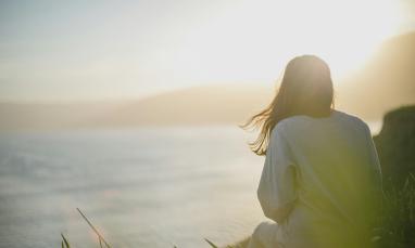 Woman watching a sunrise over an ocean