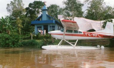 pontoon plane on the water in front of a church building