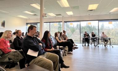 3MT 2026 audience with people sitting in a room with large windows