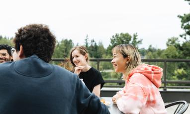 student sitting at table outside