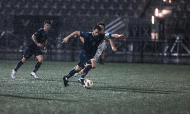 group of men wearing black jersey and playing in the field