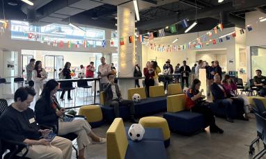group of people in the Richmond campus with World Cup decorations around the room.