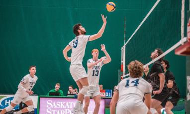 Men in white jersey playing volleyball in a court