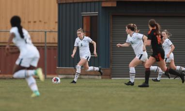 group of women wearing white jersey and playing in the field