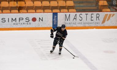 TWU student playing hockey in men's hockey game.