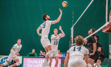 Men in white jersey playing volleyball in a court