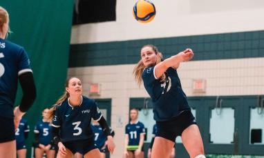 Women in blue jersey playing volleyball