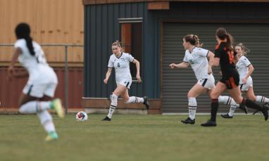 group of women wearing white jersey and playing in the field