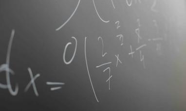 Mathematical formulas written on a classroom chalkboard.