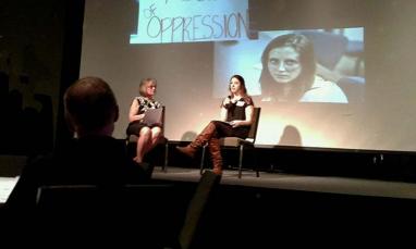 Two women sitting on stage 
