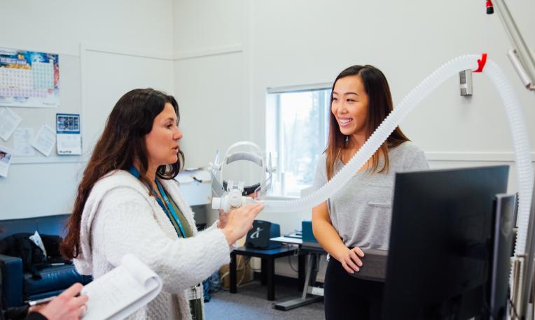 Student and instructor in lab with respitory equipment.