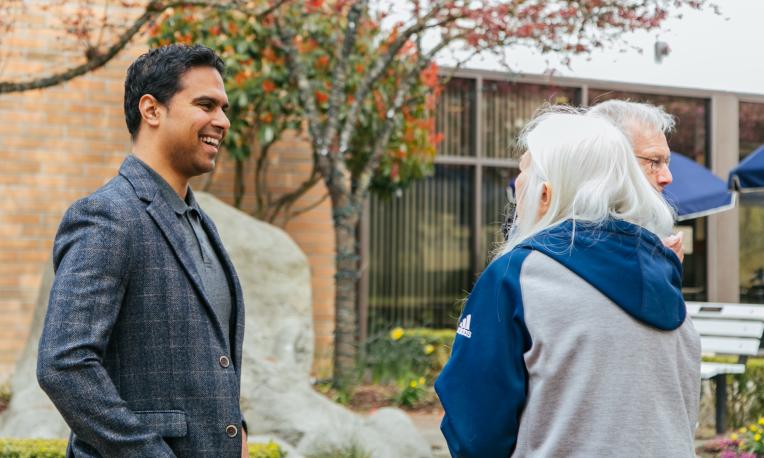 man talking with older women in front of Reimer