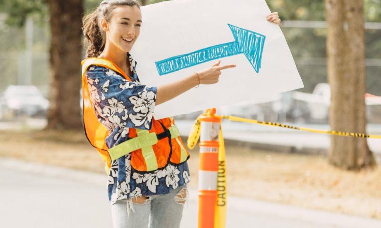 Student holding an arrow sign during O-week