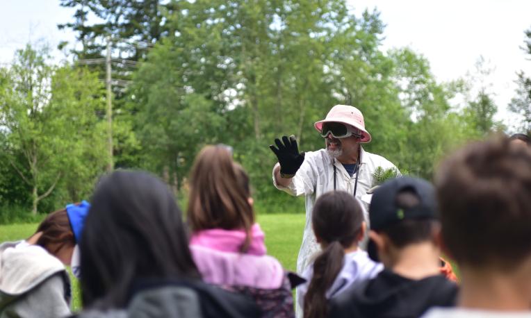 person teaching kids about science outside