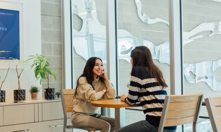 two people meeting at table and smiling