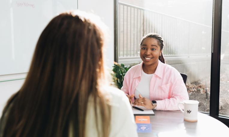 student sitting at table across from another person