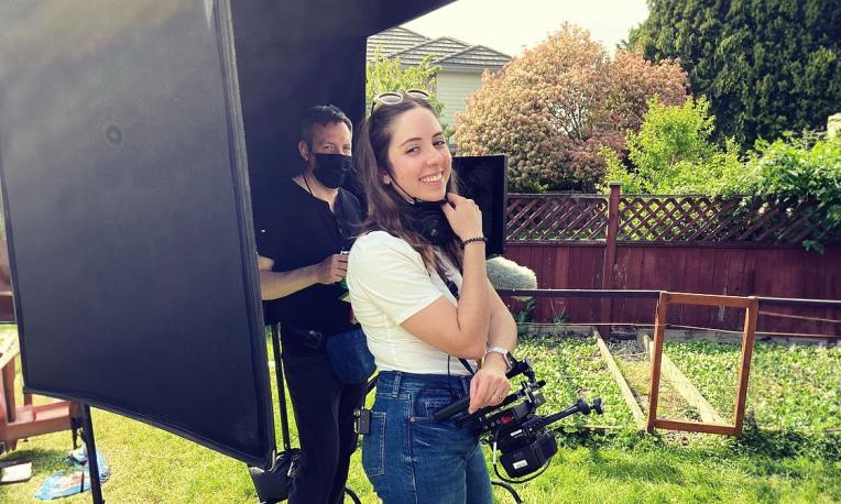woman standing in front of camera equipment