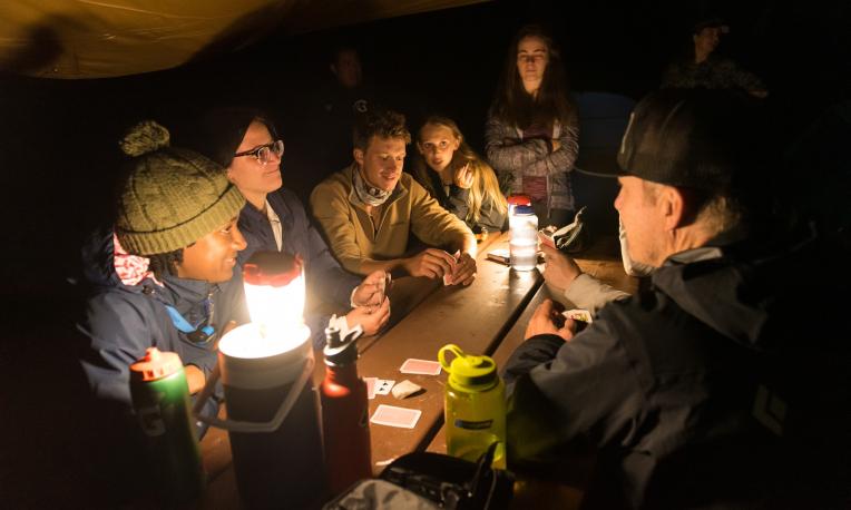 people eating together in a tent at night