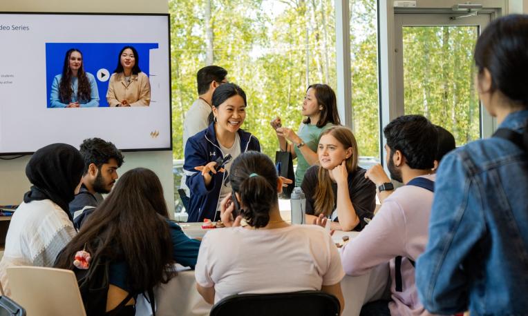 woman talking to a table of students in the Global Lounge
