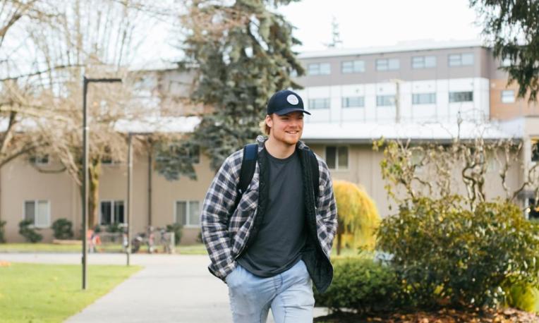 man in a flannel shirt walking down path