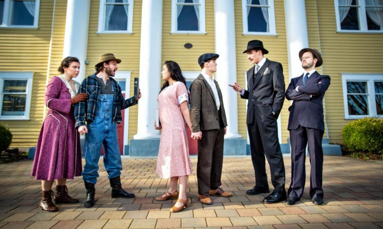 people dressed in 20s costumes in front of historic building
