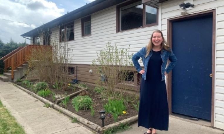 student standing in front of a house